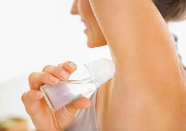 Close-up em jovem mulher aplicando desodorizante na axila — Fotografia de Stock