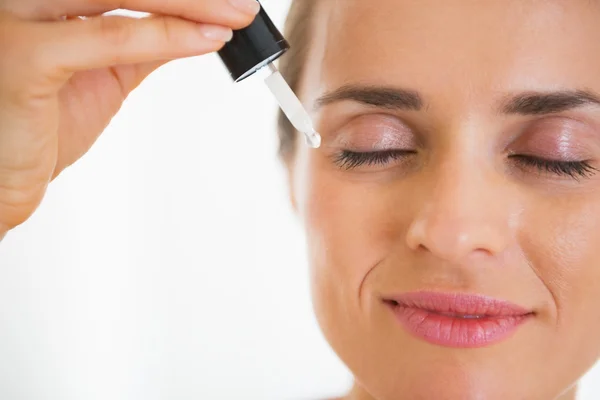 Gelukkig jonge vrouw cosmetische serum toe te passen — Stockfoto