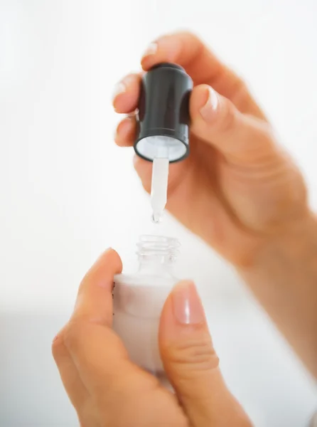 Closeup on young woman using cosmetic elixir — Stock Photo, Image