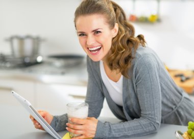 gülümseyen genç kadın ile güler yüzlü mutfak tablet PC'yi kullanma