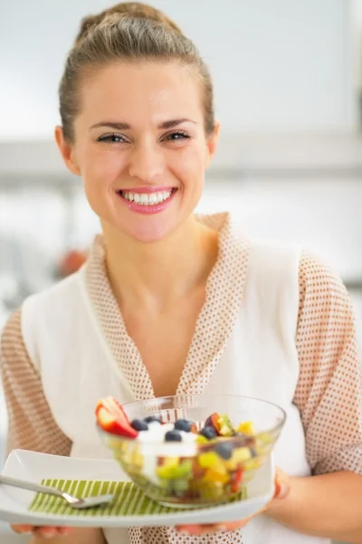Lachende jonge vrouw met verse fruitsalade — Stockfoto