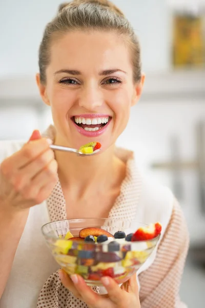 Sorridente giovane donna mangiare macedonia di frutta fresca — Foto Stock