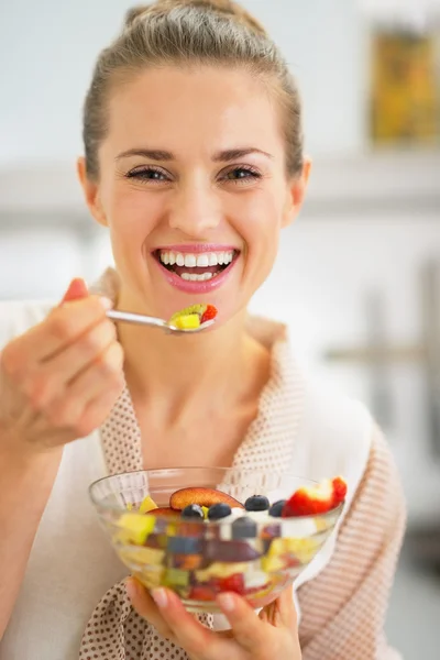 Mujer joven sonriente comiendo ensalada de frutas frescas — Foto de Stock