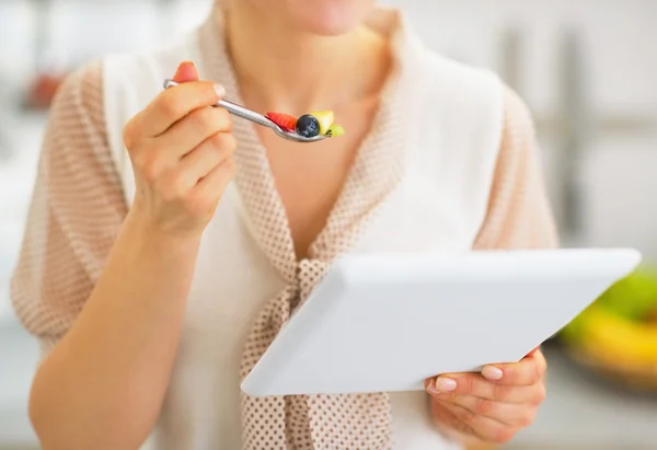 Close-up em jovem com tablet pc comendo salada de frutas — Fotografia de Stock