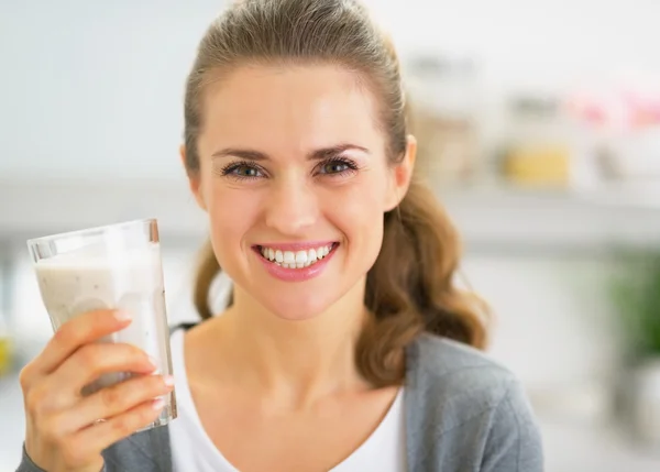 Portrait of happy young woman drinking smoothie in kitchen — Stock Photo, Image
