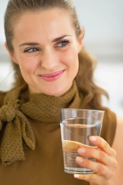 Junge Hausfrau trinkt Glas Wasser — Stockfoto