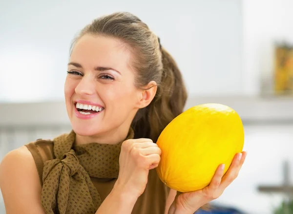 Sonriente joven ama de casa comprobar la madurez de melón —  Fotos de Stock