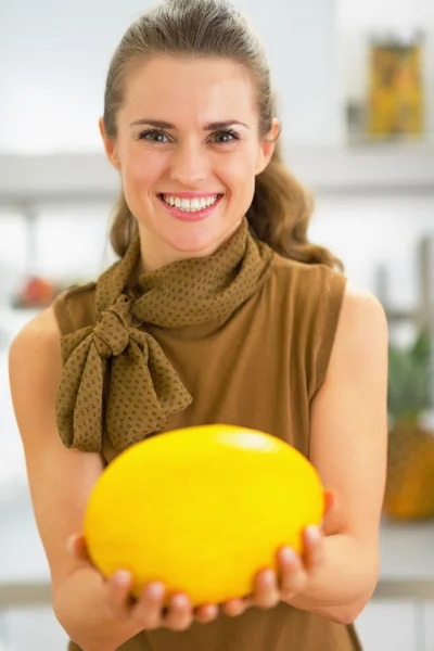 Junge Hausfrau zeigt Melone — Stockfoto