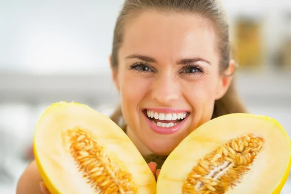 Mujer joven sonriente mostrando melón — Foto de Stock