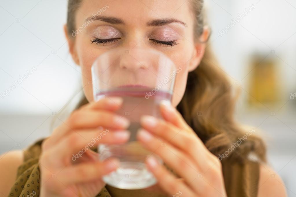 Young housewife drinking water