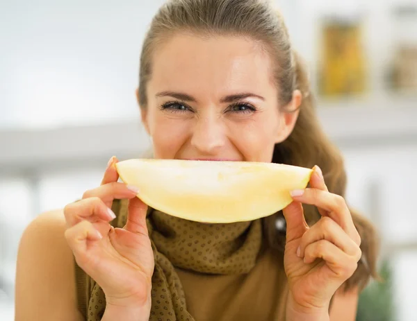 Jonge vrouw met meloen segment voor mond — Stockfoto