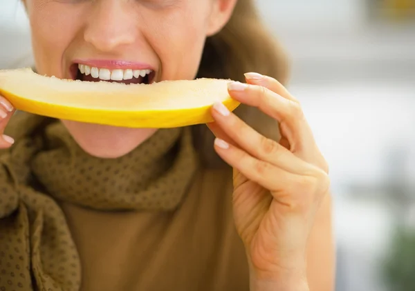 Gros plan sur jeune femme mangeant du melon dans la cuisine — Photo