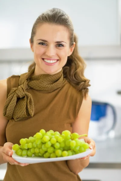 Jovem feliz mostrando ramo de uvas — Fotografia de Stock