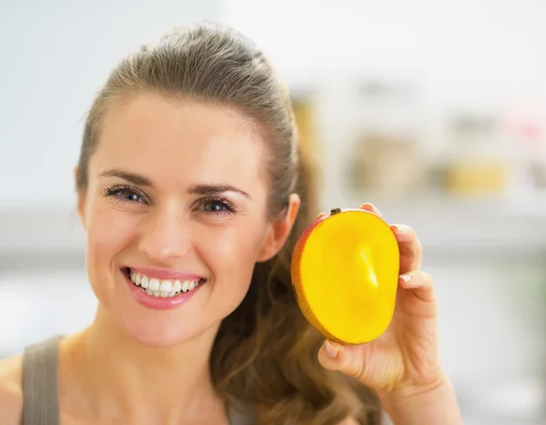 Happy young woman showing mango — Stock Photo, Image