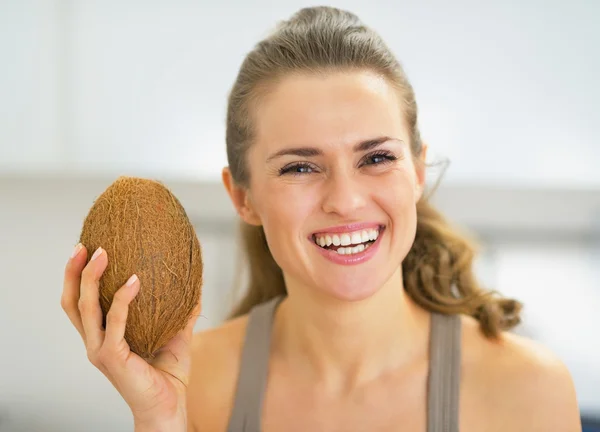 Счастливая молодая женщина показывает кокос — стоковое фото