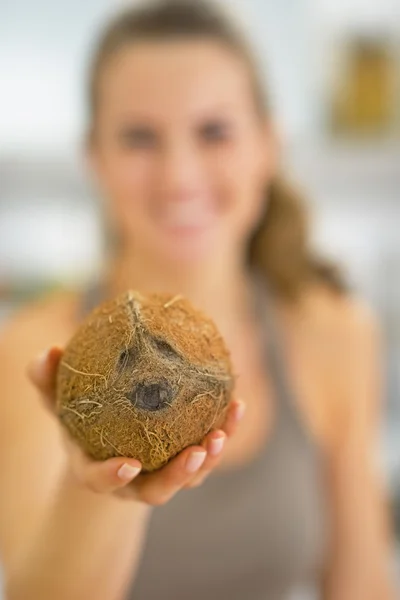 Close-up em feliz jovem mulher mostrando coco — Fotografia de Stock