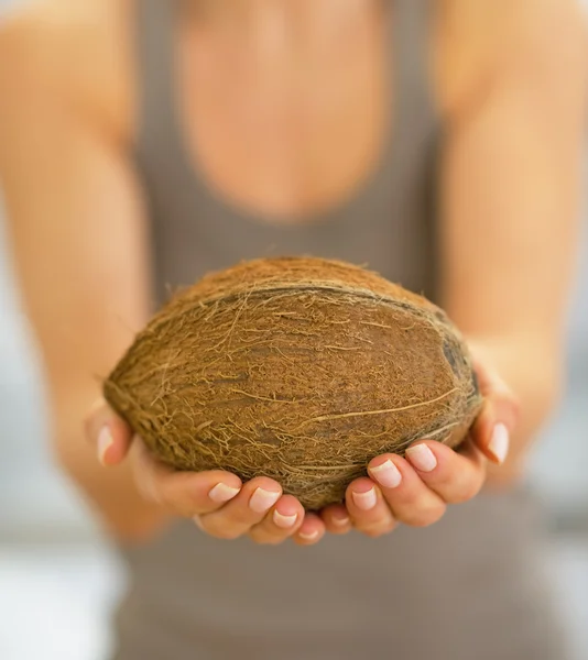 Closeup on happy young woman showing coconut — Stock Photo, Image