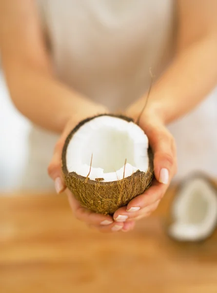 Fechar em jovem mulher mostrando metade de coco — Fotografia de Stock