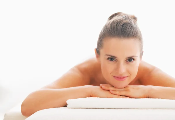 Portrait of happy young woman laying on massage table — Stock Photo, Image