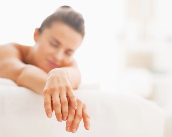 Close-up em relaxado jovem mulher que coloca na mesa de massagem — Fotografia de Stock