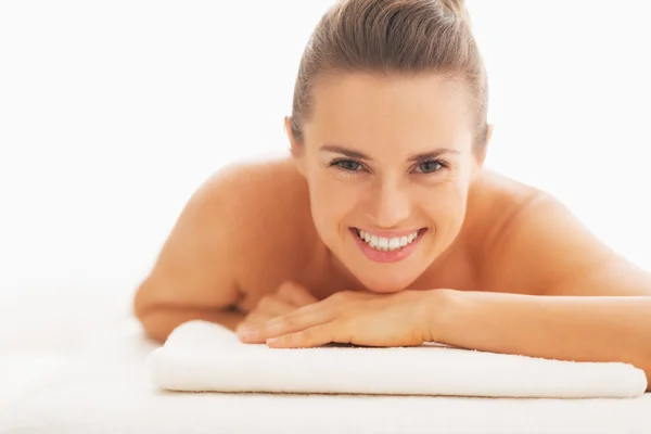 Retrato de mulher jovem sorrindo que põe na mesa de massagem — Fotografia de Stock