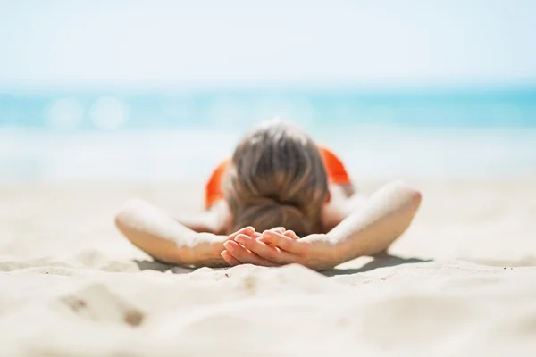 Junge Frau am Strand liegend. Rückansicht — Stockfoto