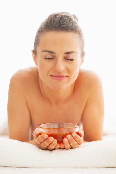 Glückliche junge Frau liegt auf Massagetisch mit Honigteller — Stockfoto
