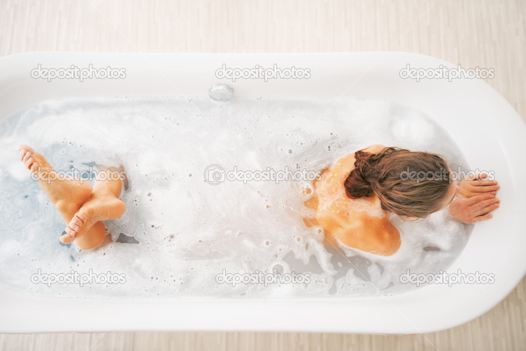 Young woman washing in bathtub