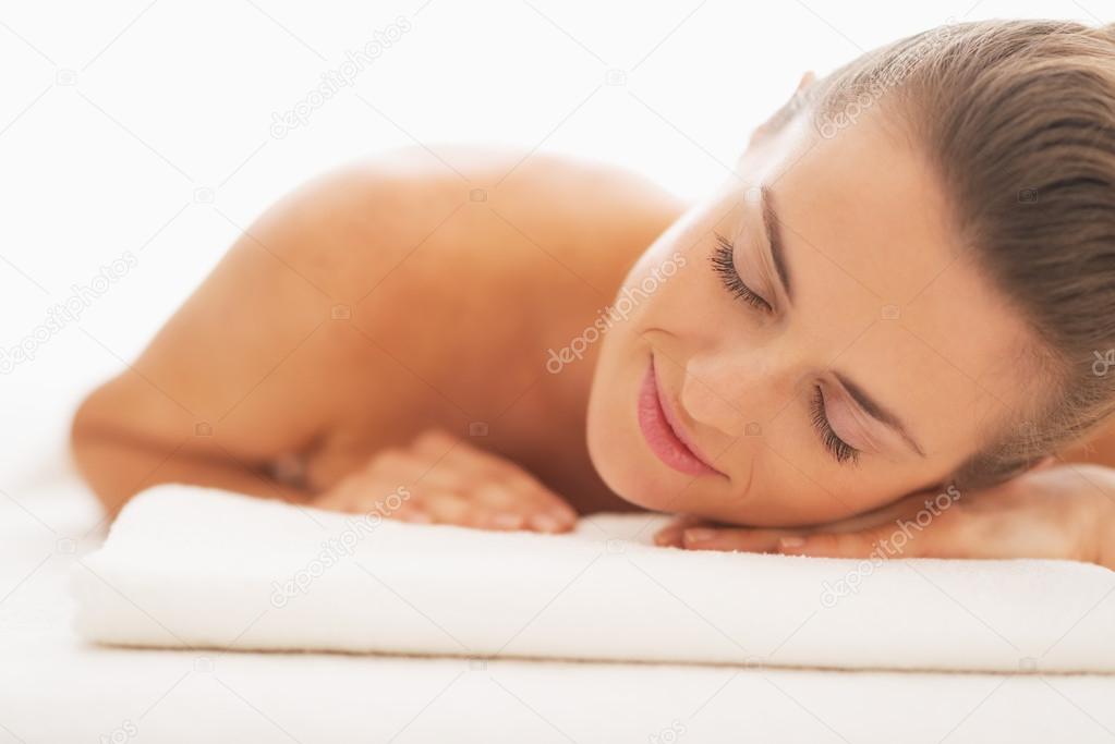 Relaxed young woman laying on massage table