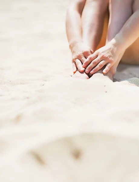 Närbild på ung kvinna sitter på stranden坐在海滩上的年轻女子的特写 — 图库照片