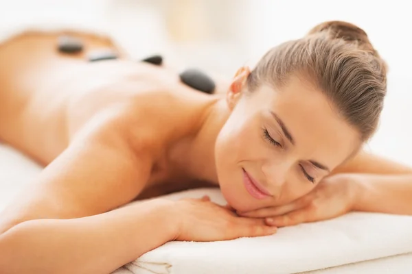 Retrato de relaxado jovem mulher recebendo massagem de pedra quente — Fotografia de Stock