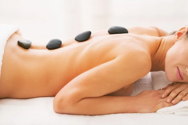 Närbild på ung kvinna får massage med varma stenar — Stockfoto