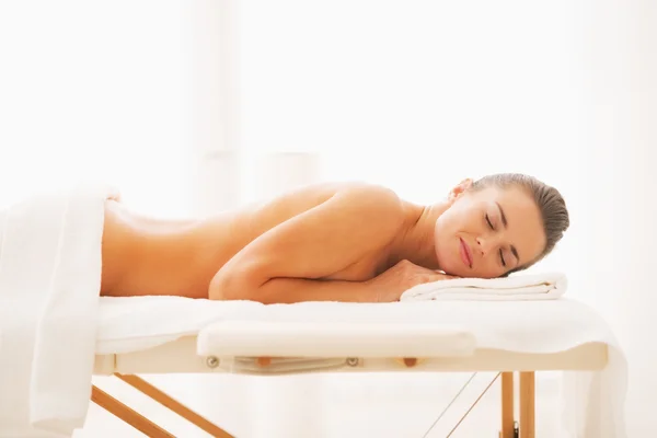 Relaxed young woman laying on massage table — Stock Photo, Image