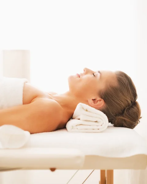 Portrait of happy young woman laying on massage table — Stock Photo, Image