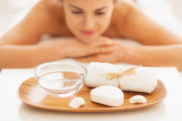 Closeup on spa therapy ingredients and relaxed young woman in background — Stock Photo, Image