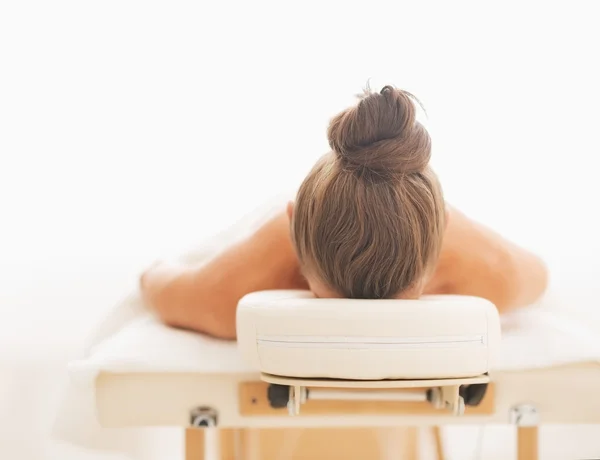 Молода жінка лежить на масажному столі — стокове фото