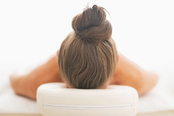 Mulher que coloca na mesa de massagem — Fotografia de Stock