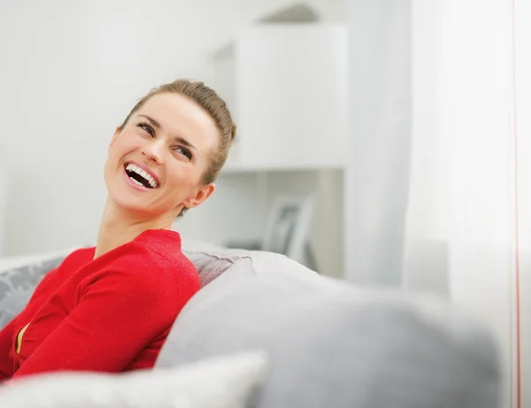 Jeune femme assise sur divan et regardant sur l'espace de copie — Photo