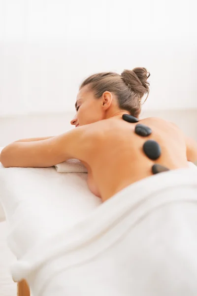 Jeune femme recevant un massage aux pierres chaudes — Photo