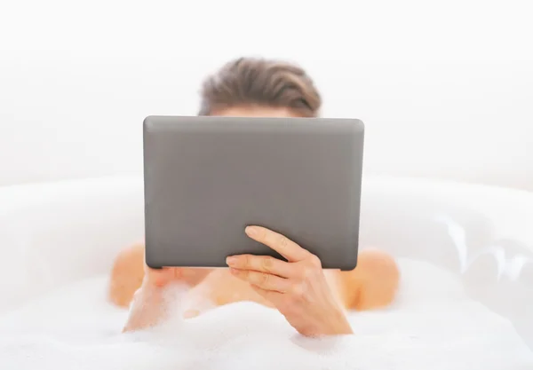 Mujer joven usando Tablet PC en la bañera —  Fotos de Stock