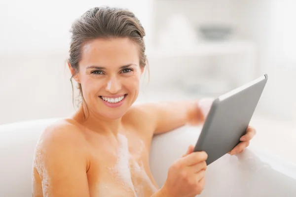 Heureuse jeune femme utilisant tablette pc dans la baignoire — Photo