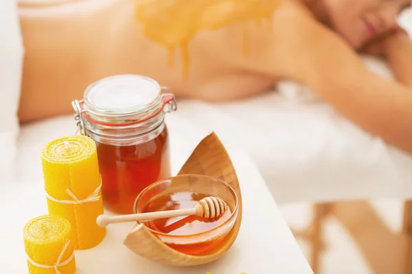 Primeros planos de los ingredientes de la terapia de spa de miel y la mujer joven relajada —  Fotos de Stock
