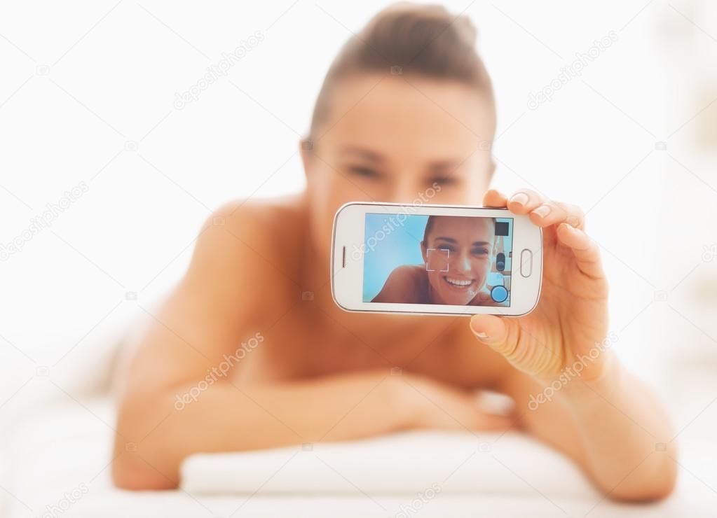 Closeup on young woman taking self photo while laying on massage