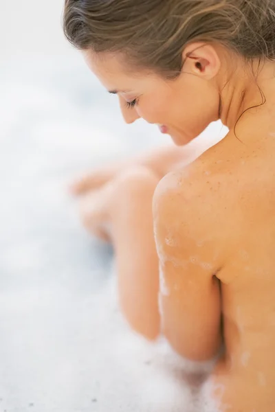 Happy young woman sitting in bathtub — Stock Photo, Image