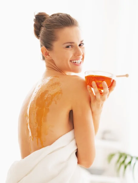 Portrait of happy young woman holding plate with honey — Stock Photo, Image