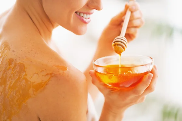 Close-up em jovem com mel na parte de trás segurando prato de mel — Fotografia de Stock