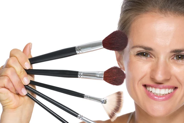 Young woman showing makeup brushes — Stock Photo, Image