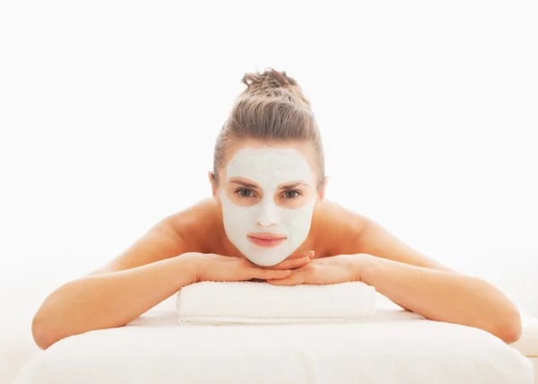 Jonge vrouw met revitaliserende masker op gezicht MASSAGETAFEL opleggen — Stockfoto