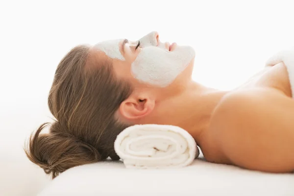 Profile portrait of young woman with revitalising mask on face laying on massage table — Stock Photo, Image