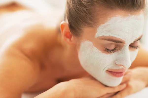 Genç bayanla rahat: Canlandırıcı maske yüz masaj masasında döşeme — Stok fotoğraf